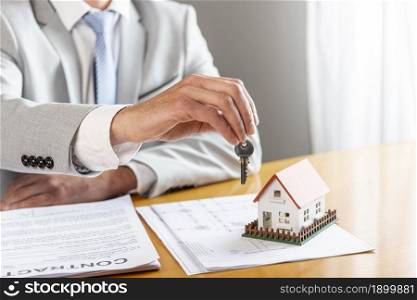 person holding house keys toy model house desk. Resolution and high quality beautiful photo. person holding house keys toy model house desk. High quality beautiful photo concept
