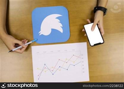 person holding mobile phone analyzing twitter graph