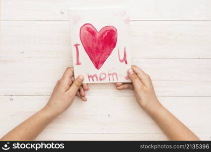 person holding paper with i love you mom inscription