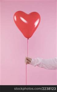 person holding red balloon with thread