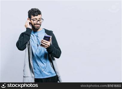 Person listening to music with his cell phone with headphones isolated, people enjoying music with headphones isolated, cheerful guy listening to music with his cell phone isolated