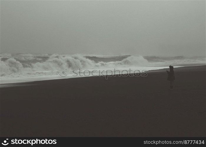 Person near stormy sea monochrome landscape photo. Beautiful nature scenery photography with sky on background. Idyllic scene. High quality picture for wallpaper, travel blog, magazine, article. Person near stormy sea monochrome landscape photo
