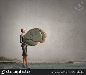 Person of great mind. Attractive businesswoman holding big brain concept in palms
