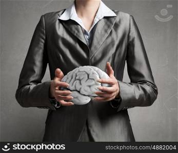 Person of great mind. Close up of businesswoman holding brain concept in palms