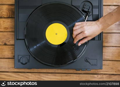 person playing vinyl disk vintage music player