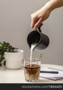 person pouring cream coffee glass. High resolution photo. person pouring cream coffee glass. High quality photo