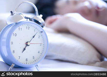 person pushing snooze on clock