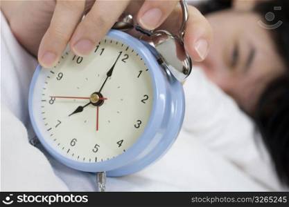 person pushing snooze on clock