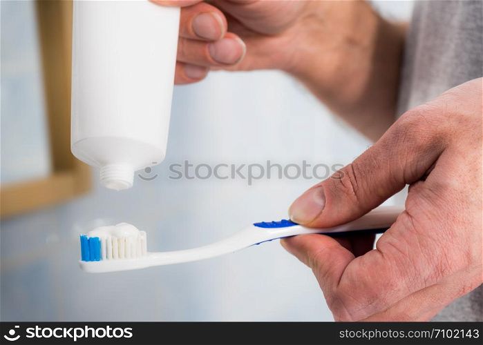 Person putting toothpaste on toothbrush. Teeth hygiene care, clean oral brush essentials concept.. Person putting toothpaste on toothbrush