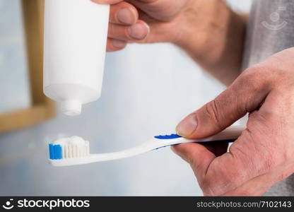 Person putting toothpaste on toothbrush. Teeth hygiene care, clean oral brush essentials concept.. Person putting toothpaste on toothbrush