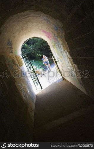 Person riding a bicycle viewed through an archway, Pont Yssoir, Le Mans, Sarthe, France