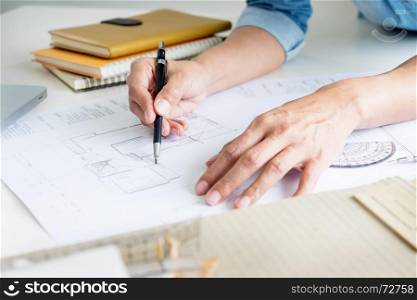 Person's engineer Hand Drawing Plan On Blue Print or working project in his office with architect equipment