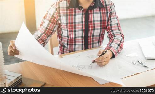 Person&rsquo;s engineer Hand Drawing Plan On Blue Print with architect equipment, Architects working at the table