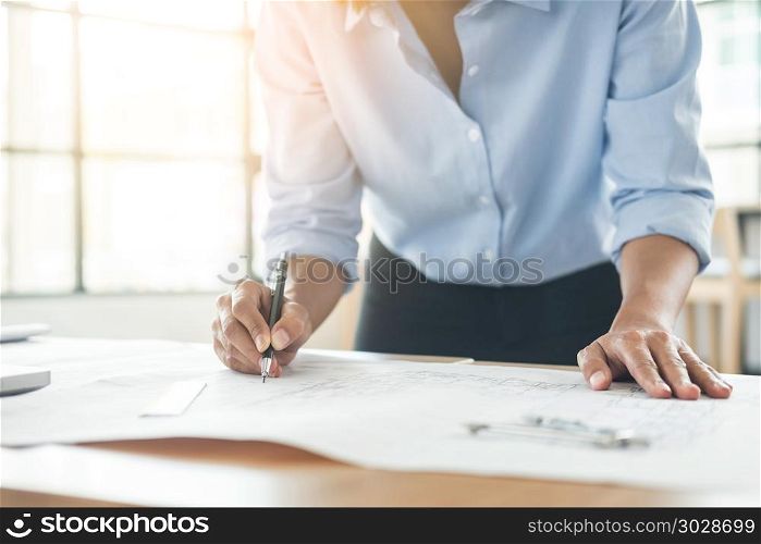 Person&rsquo;s engineer Hand Drawing Plan On Blue Print with architect equipment, Architects working at the table. Person&rsquo;s engineer Hand Drawing Plan On Blue Print with architect