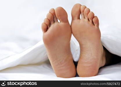 Person&rsquo;s foot in bed, close-up