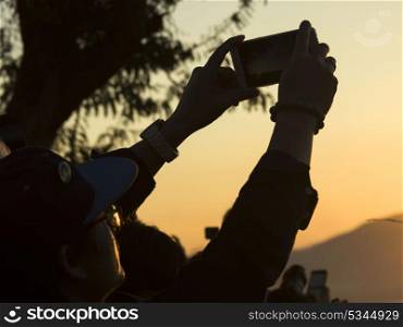 Person&rsquo;s hand taking picture with smartphone, Mount Phousi, Luang Prabang, Laos