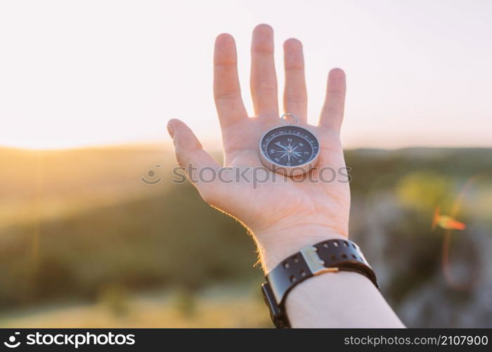 person s hand holding compass