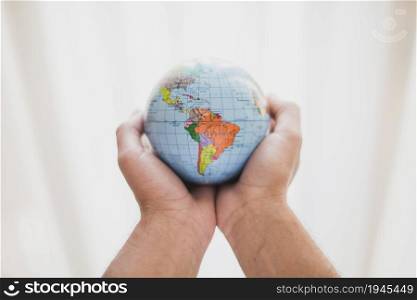 person s hand holding small globe. High resolution photo. person s hand holding small globe. High quality photo