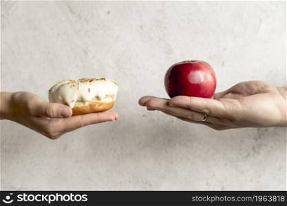 person s hand showing donut apple front concrete background. High resolution photo. person s hand showing donut apple front concrete background. High quality photo