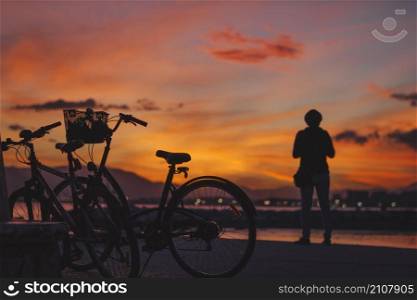 person standing bicycle sunset