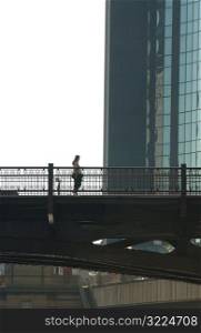Person standing on a bridge next to a high rise building in Chicago