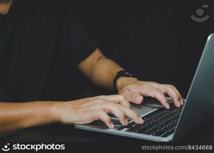 Person using in hand keyboard computer laptop on black background.