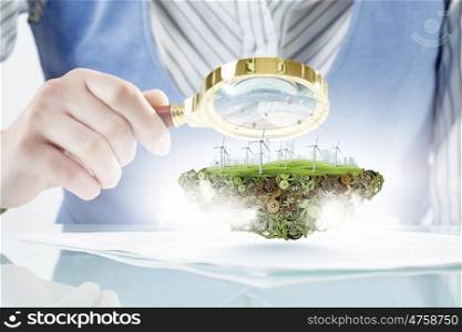 Person using magnifier for exploration. Close view of businessperson examining objects with magnifying glass