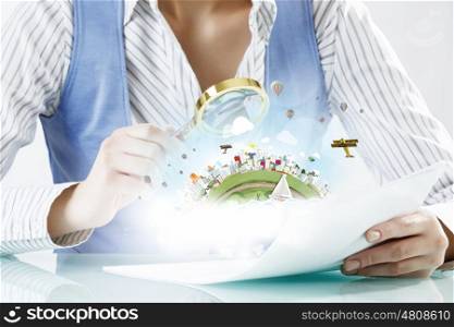 Person using magnifier for exploration. Close view of businessperson examining objects with magnifying glass