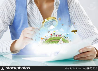 Person using magnifier for exploration. Close view of businessperson examining objects with magnifying glass