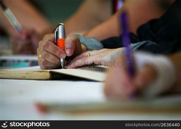 Person using pen to write in notebook