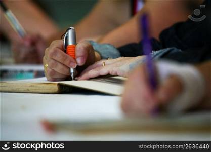 Person using pen to write in notebook
