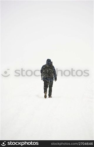 Person walking on snow, rear view