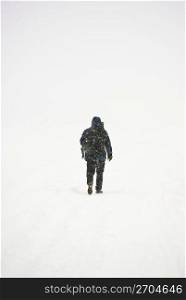 Person walking on snow, rear view