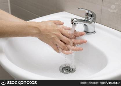 person washing hands sink
