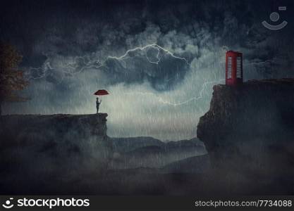 Person with an umbrella under the storm, stands on the edge of a cliff, need to pass the over side of precipice to reach a red phone booth. Fantastic scene, adventure journey, purpose and goal concept