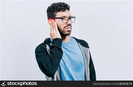Person with ear pain, on isolated background, Suffering man massaging his ear isolated, concept of person with otitis and tinnitus