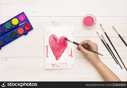 person writing i love you mom with paint brush