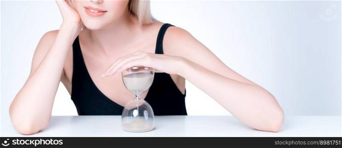 Personable model hold hourglass in aging young beauty concept of anti-aging skincare treatment for woman. Beautiful girl with smooth flawless natural facial skin in isolated background.. Personable beautiful woman with hourglass anti-aging as skincare concept