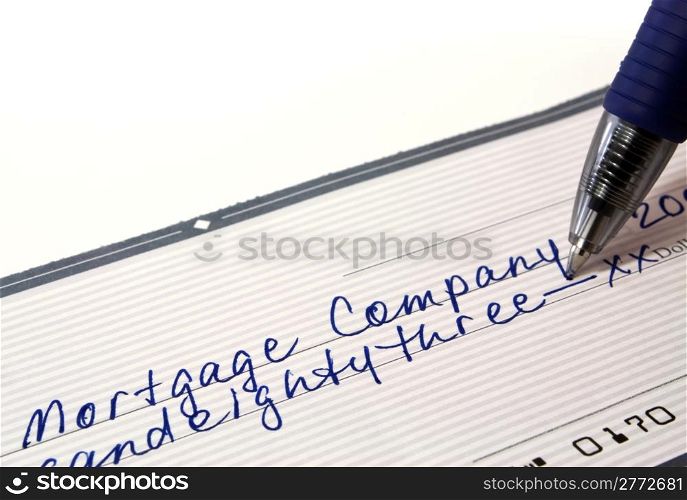 Personal bank check for mortgage payment with pen on white background with copy space.