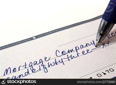 Personal bank check for mortgage payment with pen on white background with copy space.