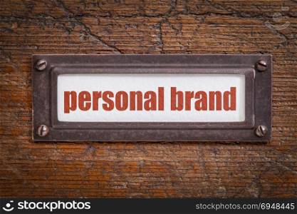 personal brand tag - file cabinet label, bronze holder against grunge and scratched wood
