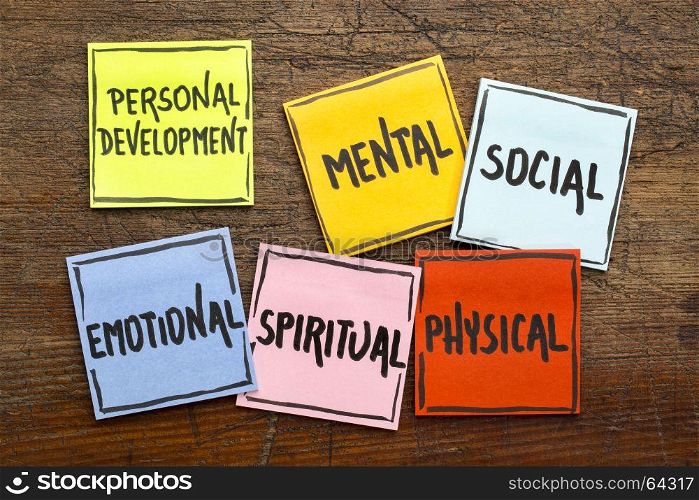 personal development concept (mental, social, emotional, spiritual, physical) - handwriting in black ink on sticky notes against rustic wood