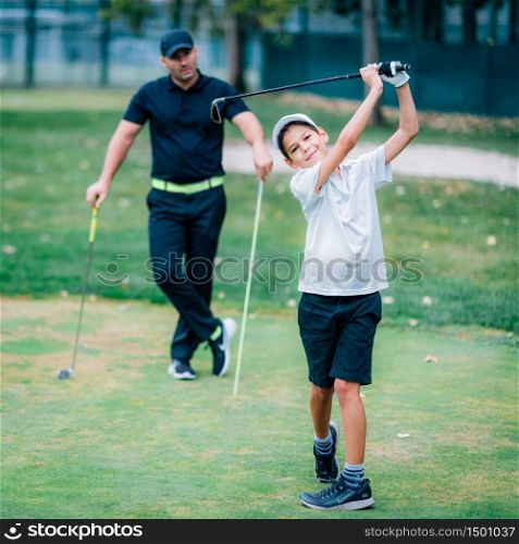 Personal Golf Lessons. Golf Instructor Adjusting Swing of a Young Boy.