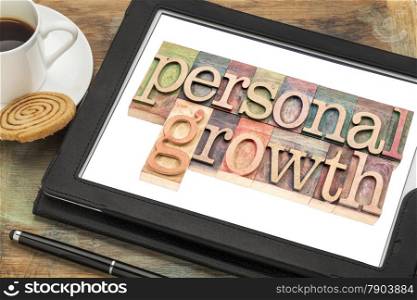 personal growth typography - text in letterpress wood type on a digital tablet with a cup of coffee