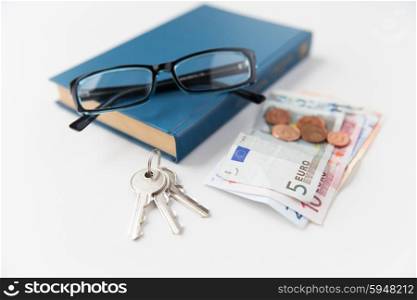 personal stuff and objects concept - close up of book, money, glasses and keys on table