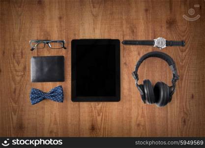 personal stuff and technology and concept - tablet pc computer with blank screen, earphones, wallet, eyeglasses and wristwatch over wooden background
