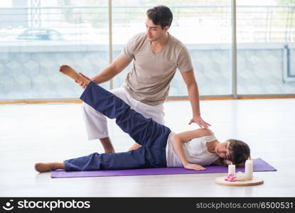 Personal trainer assisting during exercise in sports gym