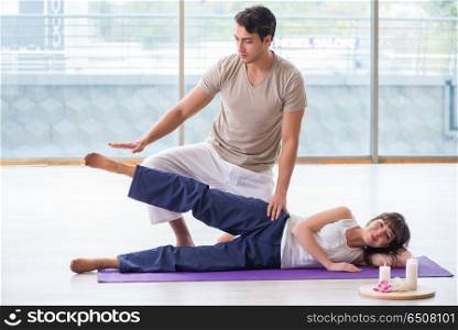 Personal trainer assisting during exercise in sports gym