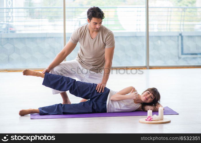 Personal trainer assisting during exercise in sports gym