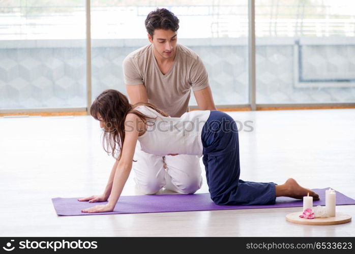 Personal trainer assisting during exercise in sports gym